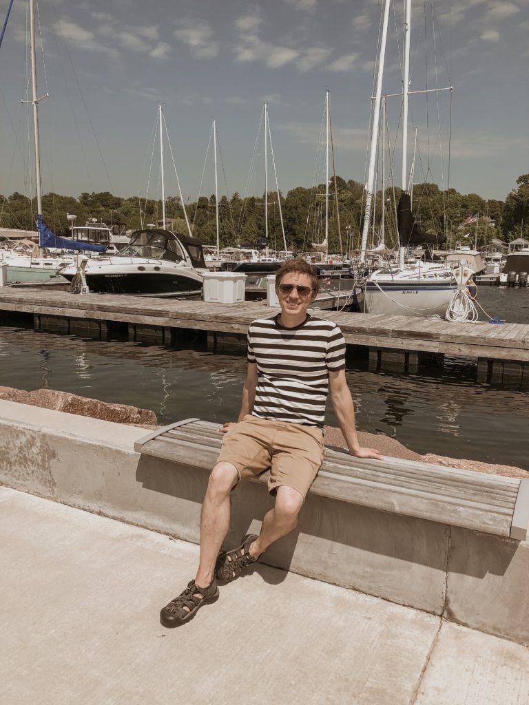 sailboats at a marina in door county, egg harbor, boats on lake michigan, everlane men's t-shirt, striped tee with khaki shorts, keen sandals
