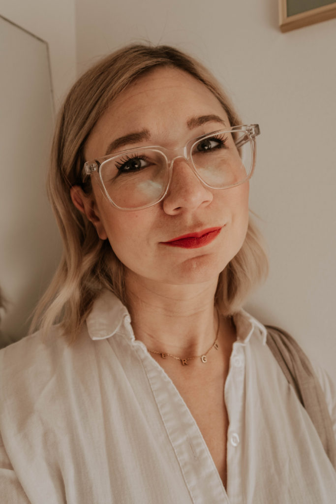clear glasses, red lipstick, gold choker necklace