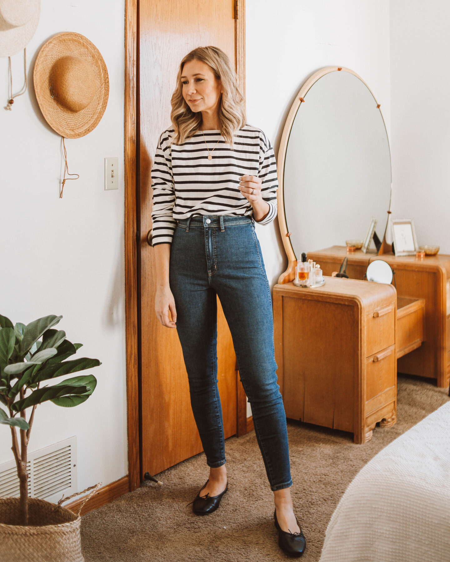 Karin Emily wears a black and white striped long sleeve tee, Everlane way high skinny jeans, and a pair of black ballet flats