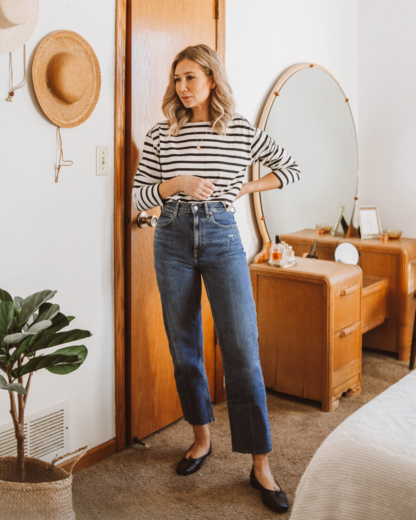 Karin Emily wears a breton black and white stripe tee, Everlane way high jeans, and black Everlane day gloves for her Everlane Denim Guide