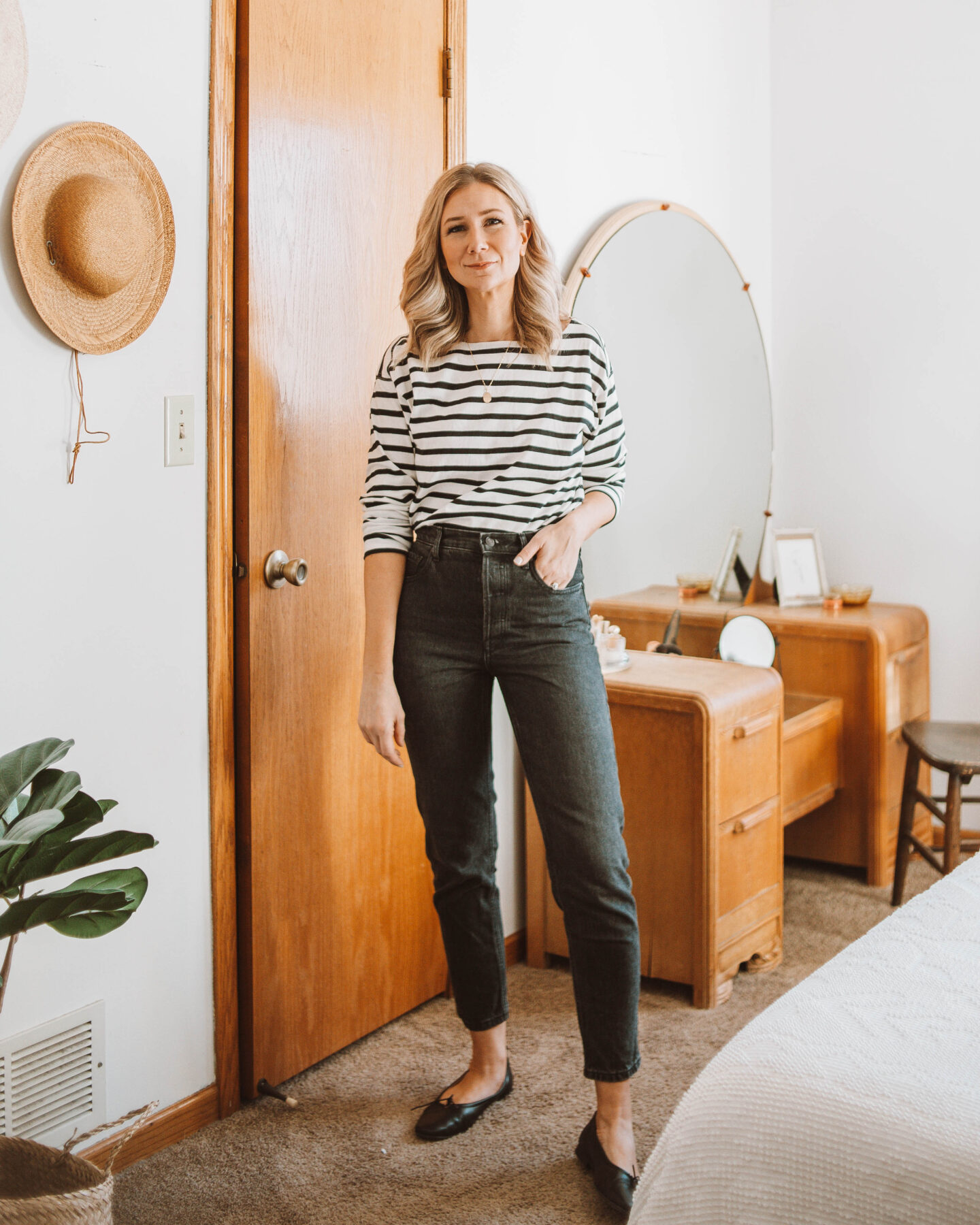 Karin Emily wears a breton black and white stripe tee, Everlane 90's cheeky jeans, and black Everlane day gloves for her Everlane Denim Guide