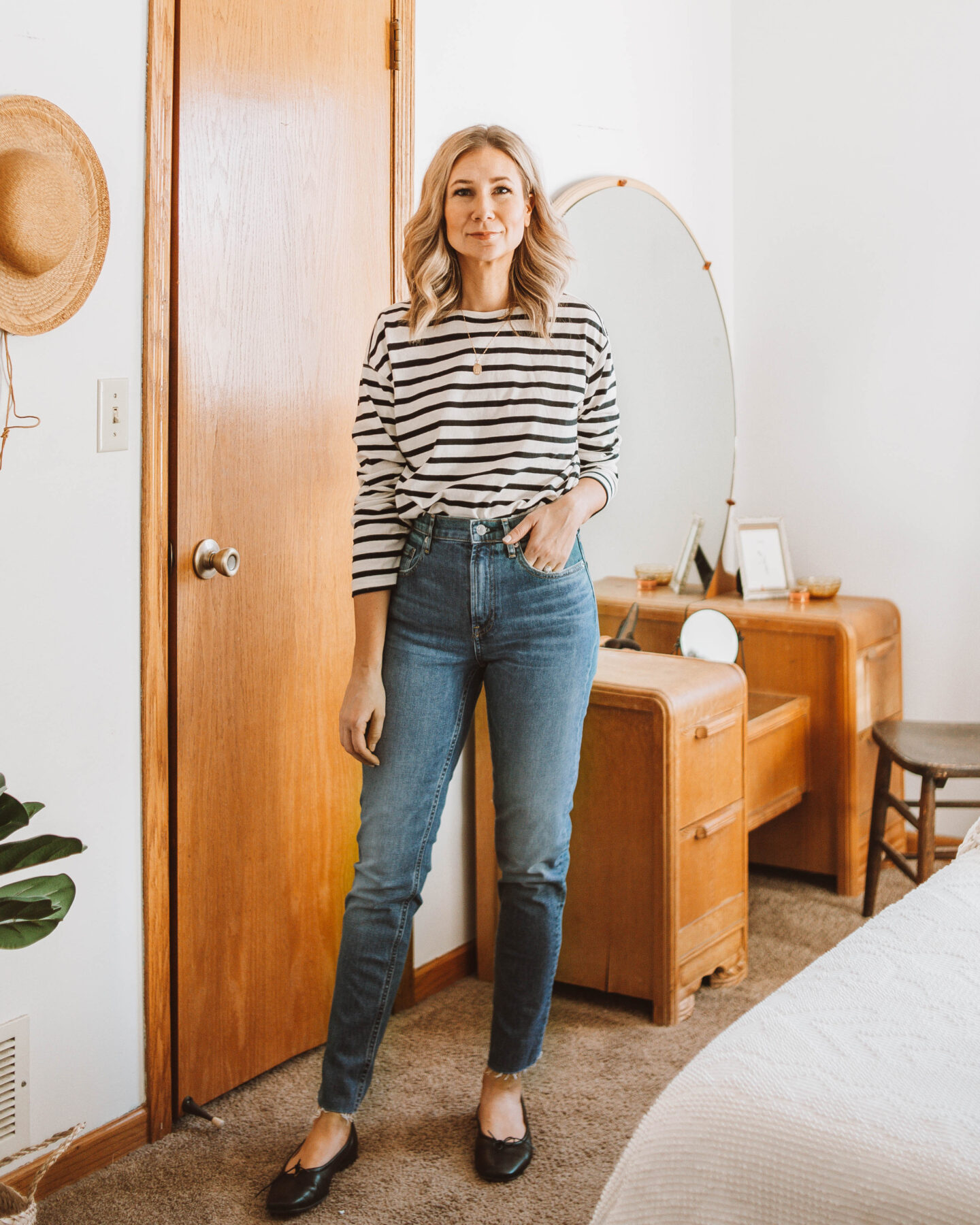 Karin Emily wears a black and white breton striped tee, Everlane cheeky jeans, and Black Everlane day gloves for her Everlane Denim Guide