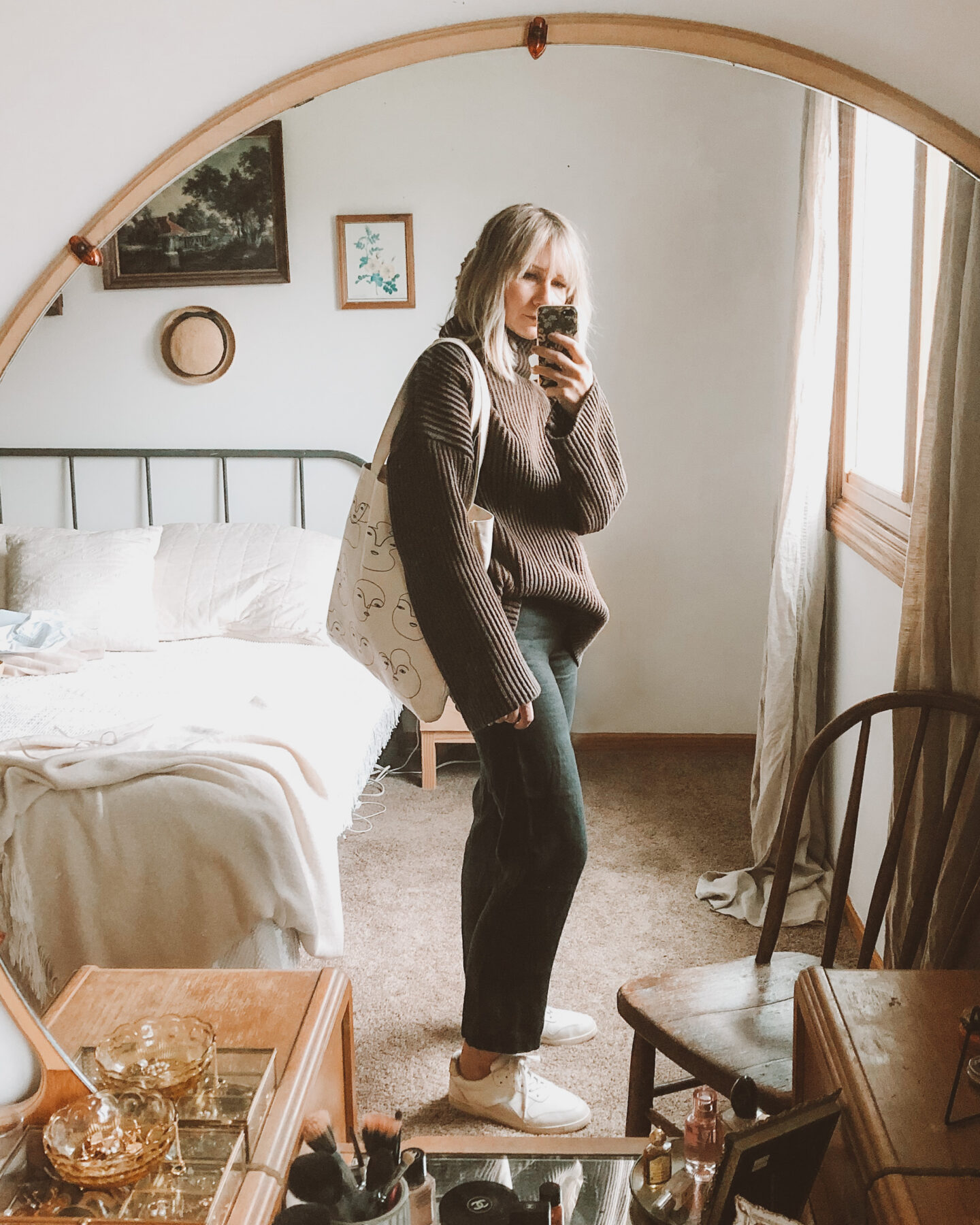 Fall Transitional Dressing: oversized brown turtleneck sweater paired with black linen pants, everlane tread sneakers, and a canvas tote bag