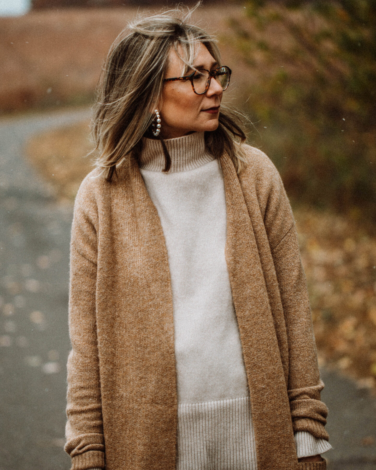 3 Cozy Outfits for Thanksgiving, camel duster maxi cardigan, taupe turtleneck sweater, blue skinny jeans, brownknee high croc effect boots, staud moon bag