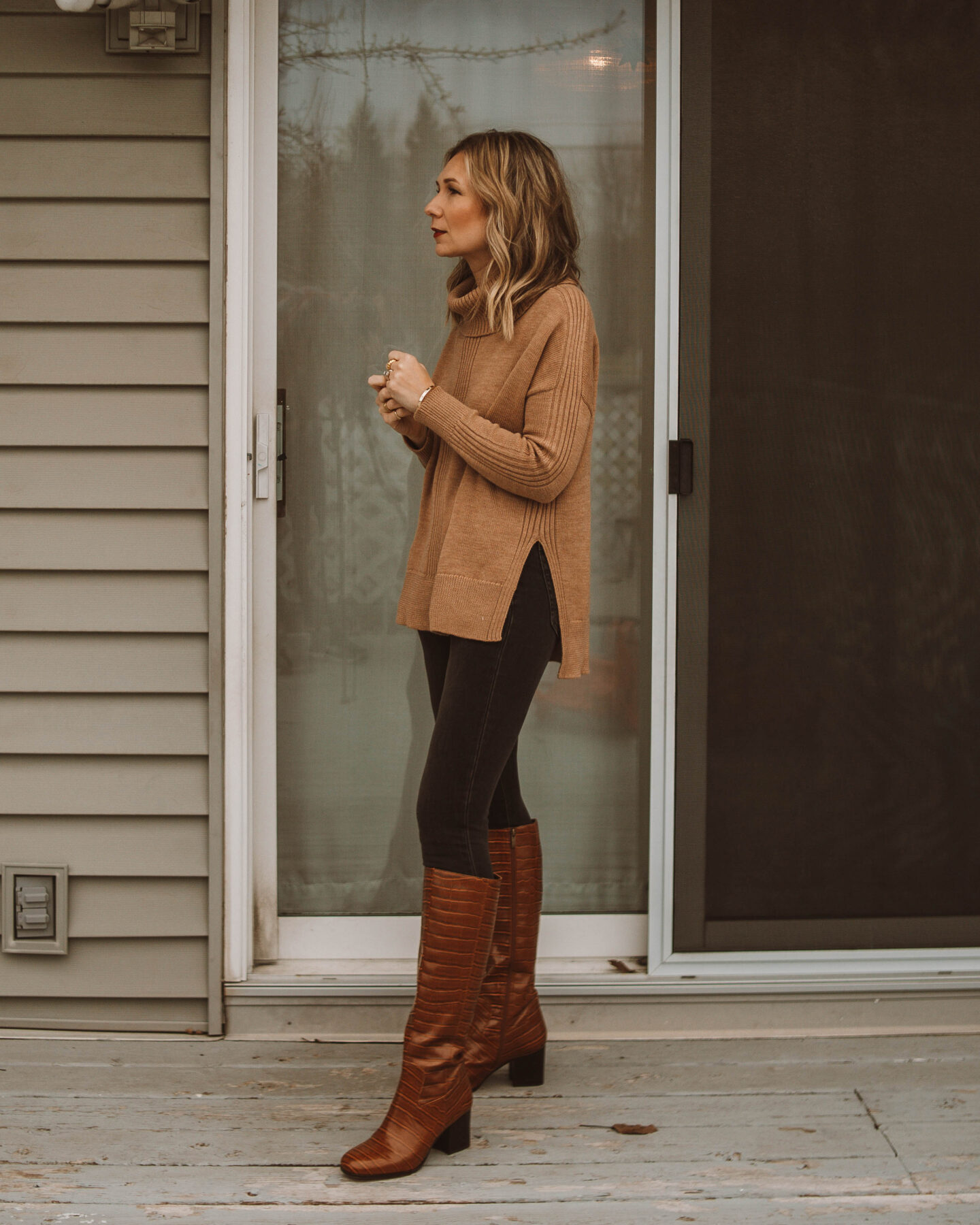 cozy at home christmas outfit ideas,camel turtleneck sweater, gray skinny jeans, croc effect boots, knee high boots