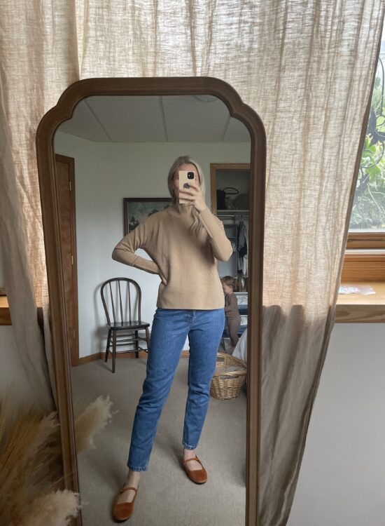 Karin Emily wears a cashmere camel colored turtleneck from Everlane
