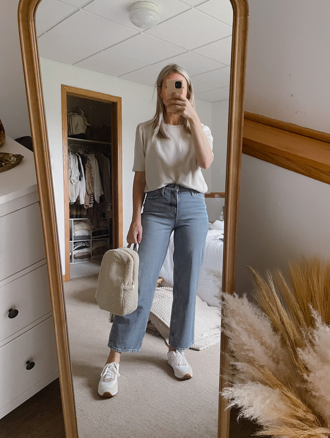 Karin Emily wears a puff sleeve sweatshirt from it is well L.A., a pair of wide leg jeans from Walmart, a sherpa backpack from studio noos, and a pair of J. Crew Sneakers