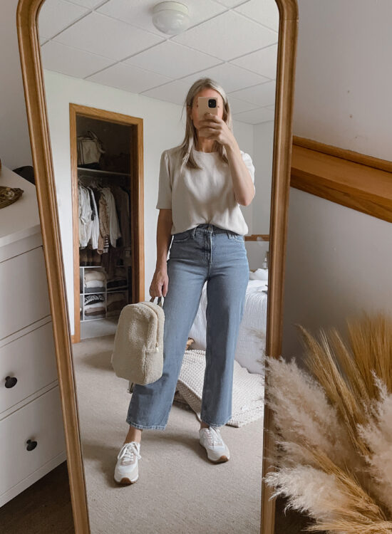 Karin Emily wears a puff sleeve sweatshirt from it is well L.A., a pair of wide leg jeans from Walmart, a sherpa backpack from studio noos, and a pair of J. Crew Sneakers