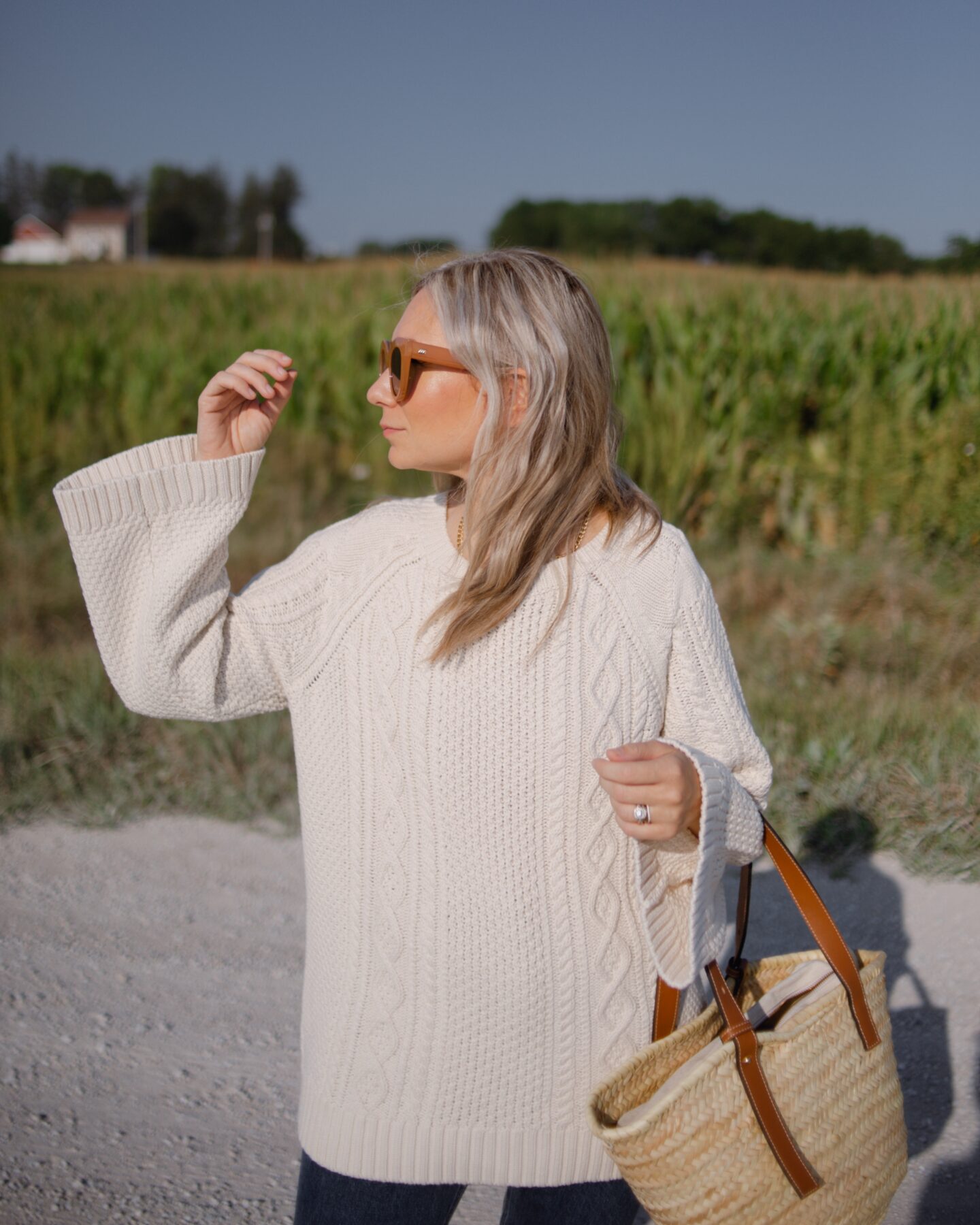 girl wearing a cozy sweater that's cableknit and oversized with bell sleeves