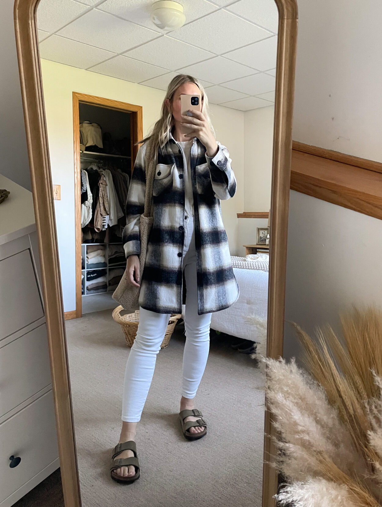 Karin Emily wears a plaid shacket over white skinny jeans and birkenstock arizonas