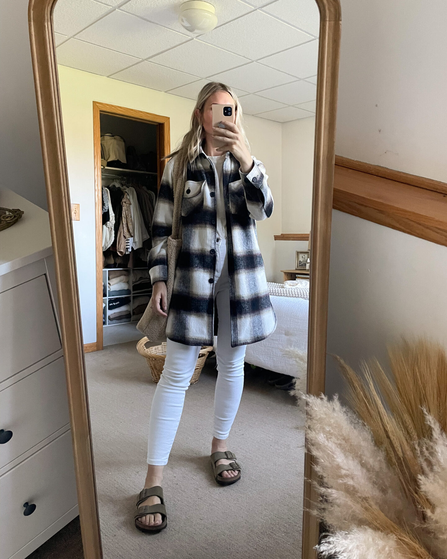 Karin Emily wears a plaid shacket over white skinny jeans and birkenstock arizonas