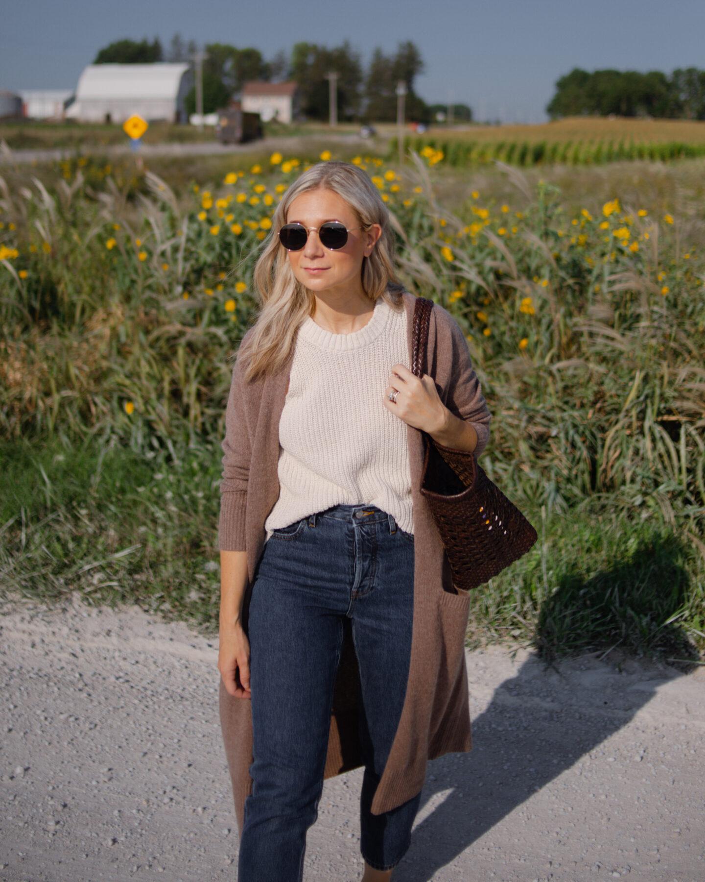Girl wearing a long cashmere cardigan and dark wash jeans with sherpa mules