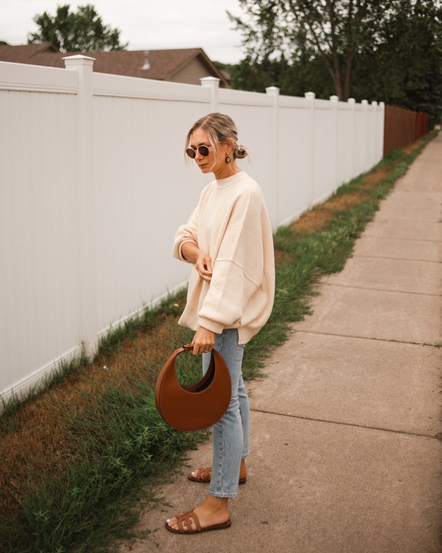 karin emily wearing a cozy sweater for fall and a pair of light wash levi's with cognac accessories