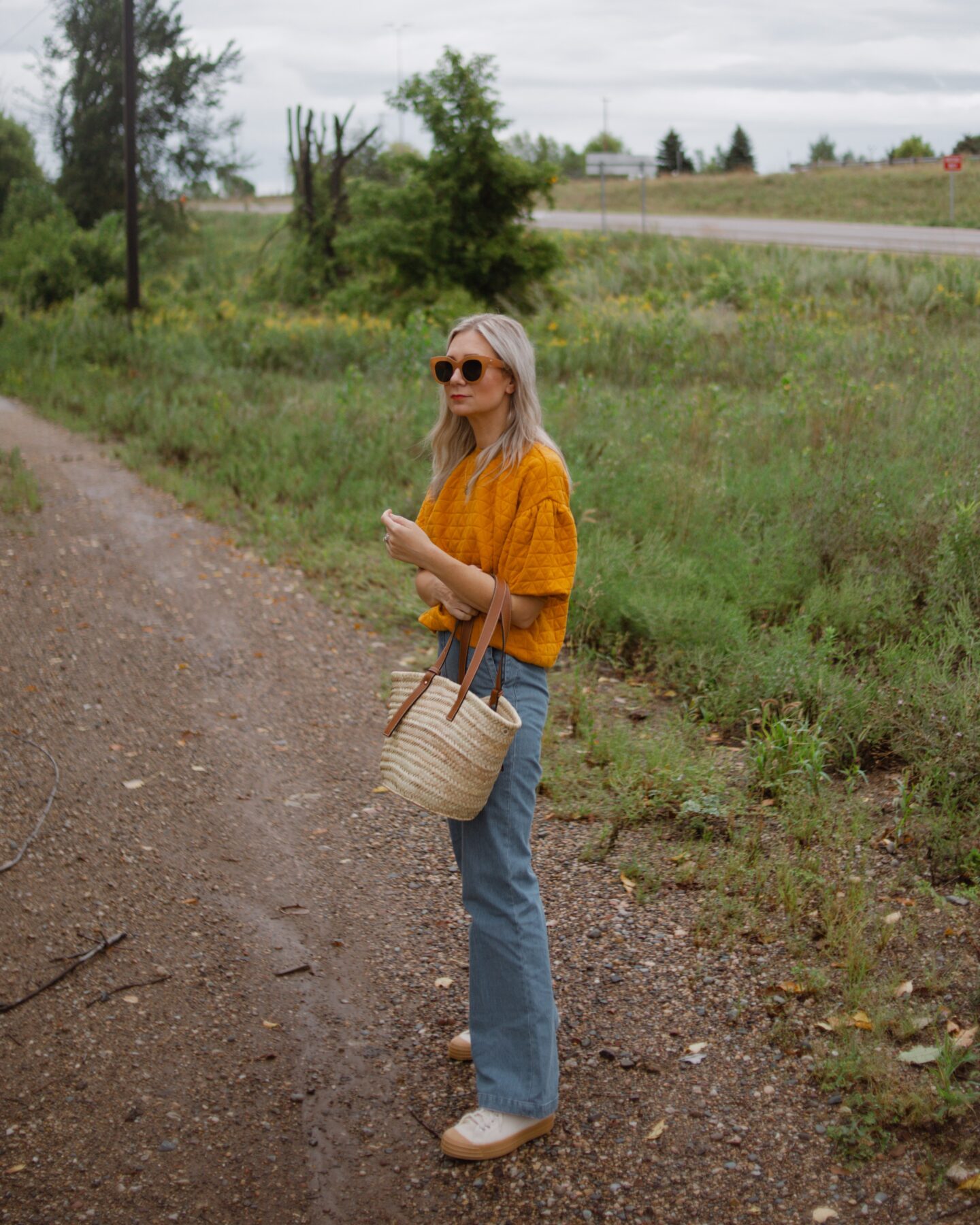 karin emily wearing a cozy sweater for fall in a bright yellow color and sezane flared jeans