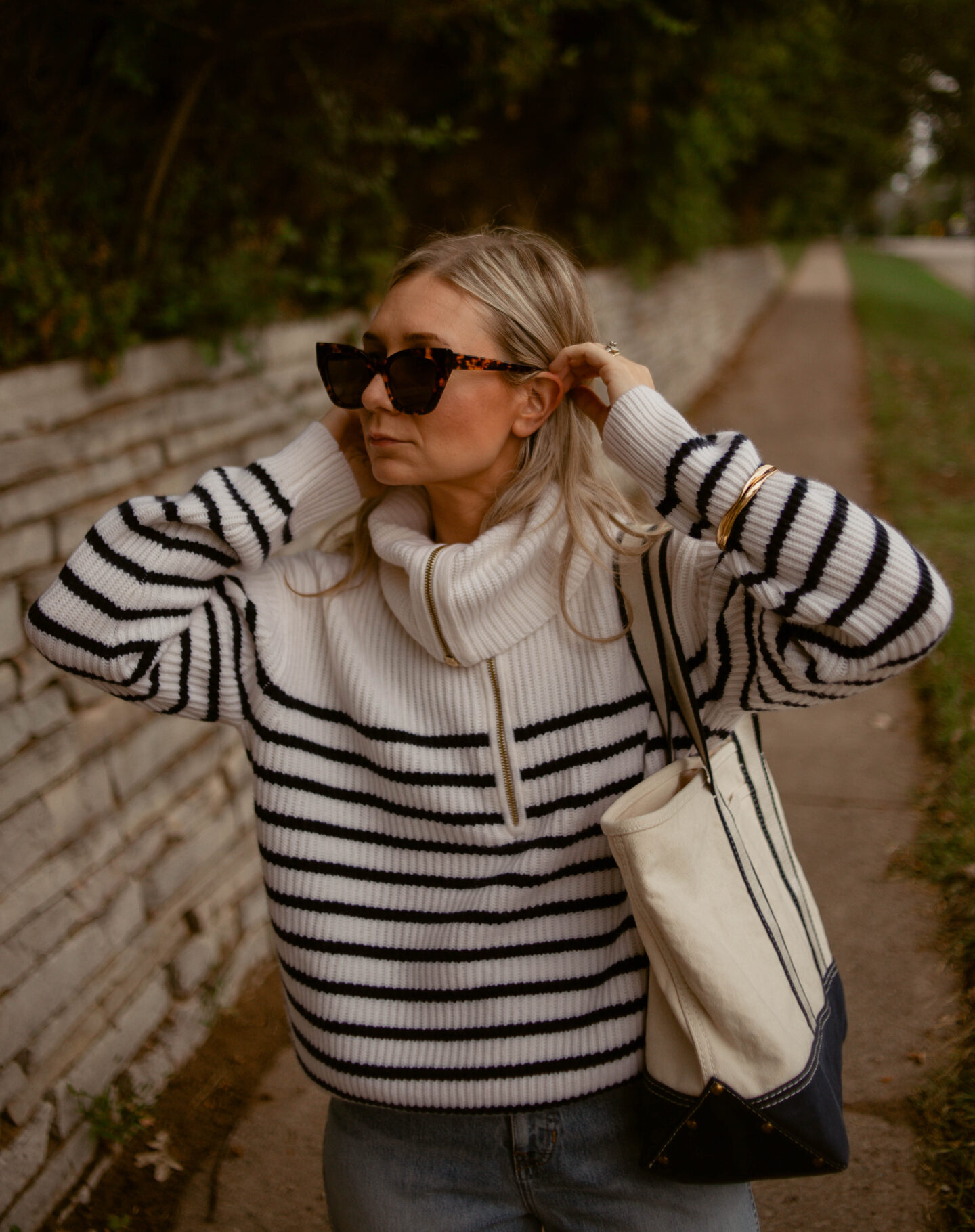 Karin Emily Wears a cashmere breton stripe sweater, light wash relaxed jeans, and sherpa mules - all from J. Crew