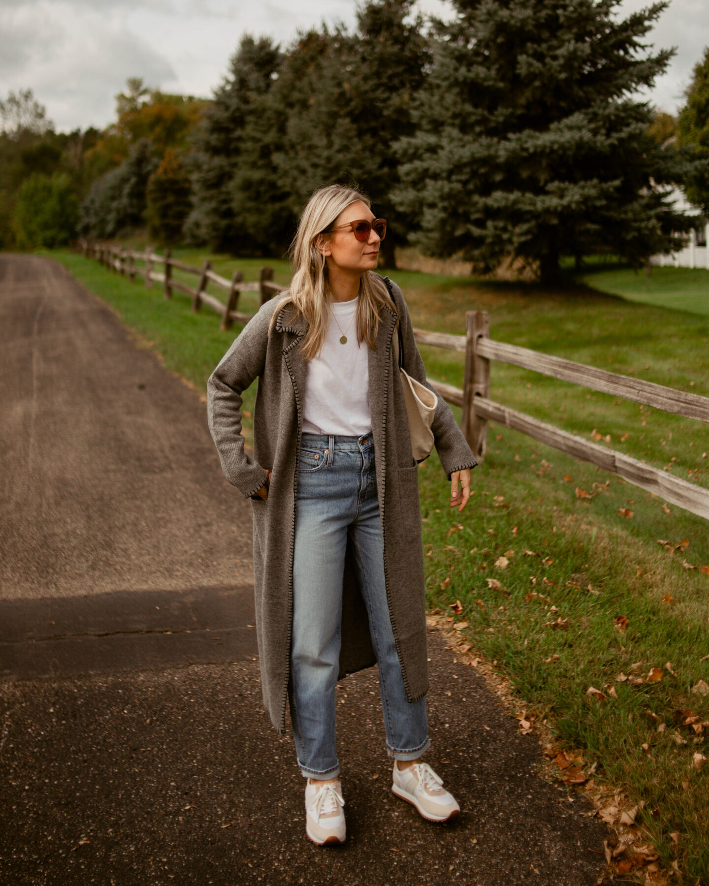 Karin Emily wears a comfy and chic fall outfit: relaxed pair of jeans and an oversized white tee under a gray maxi cardigan