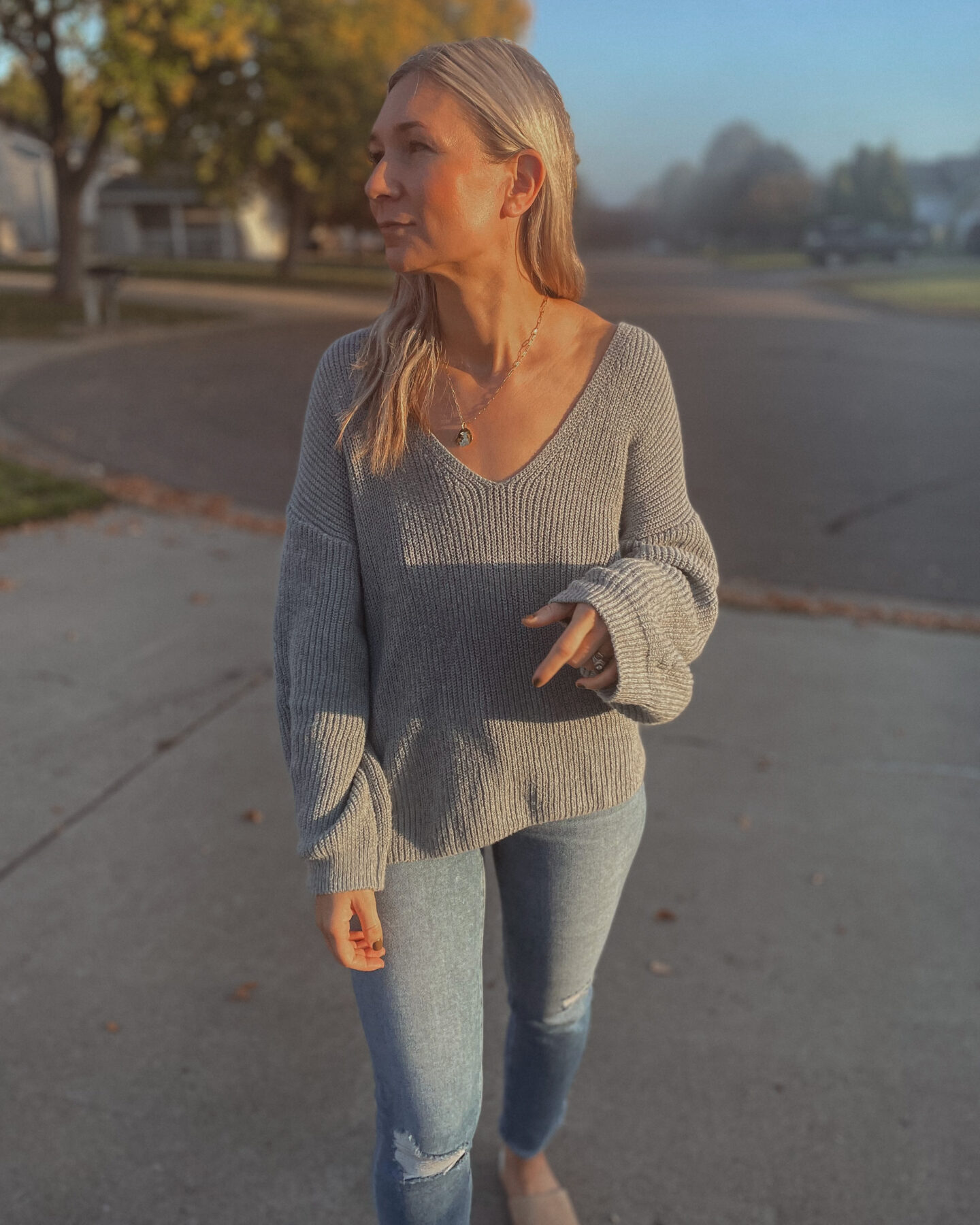 Karin Emily wearing a blue sweater, and distressed jeans