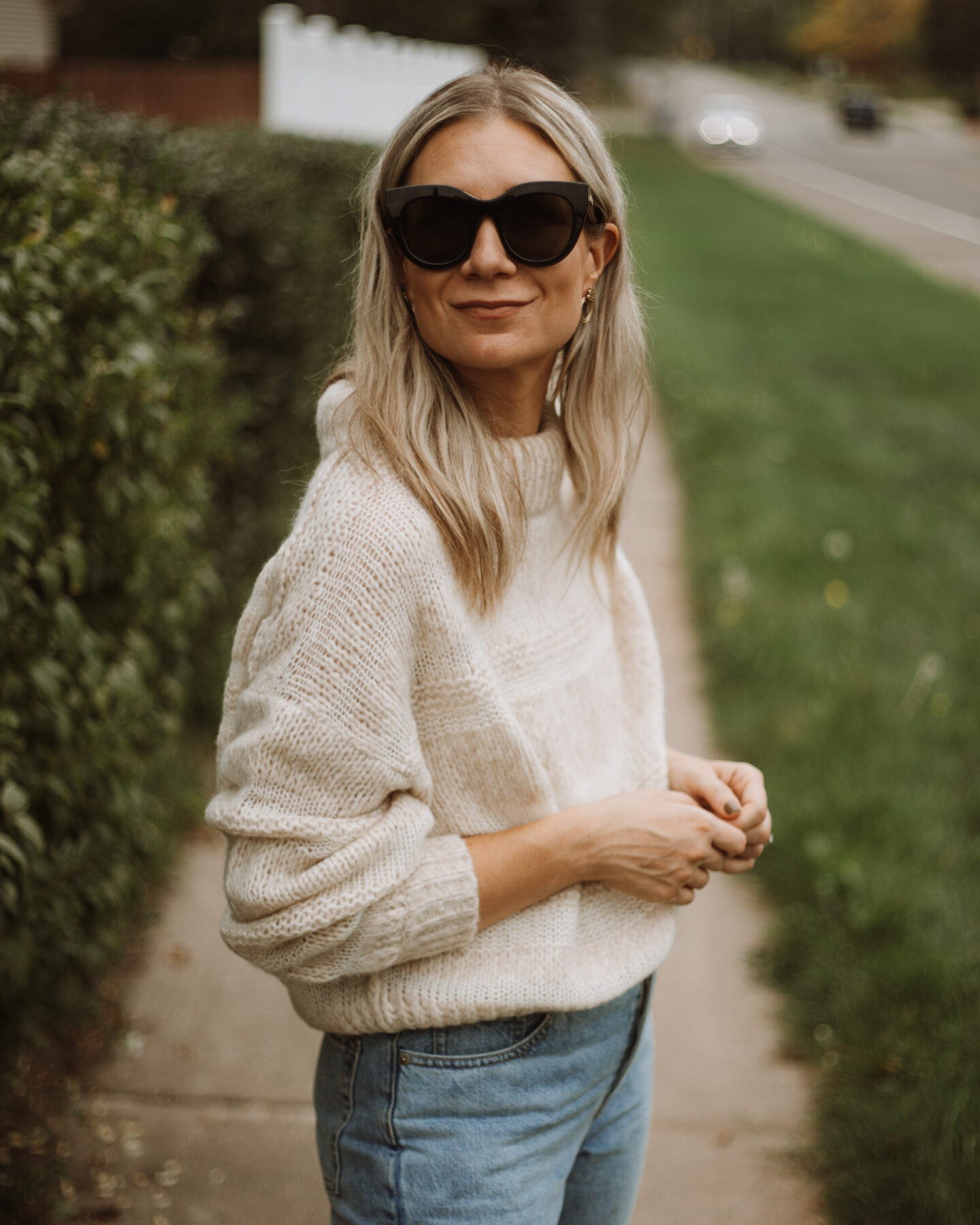 Karin Emily wears the Everlane puff sweater, light wash 90's cheeky jeans