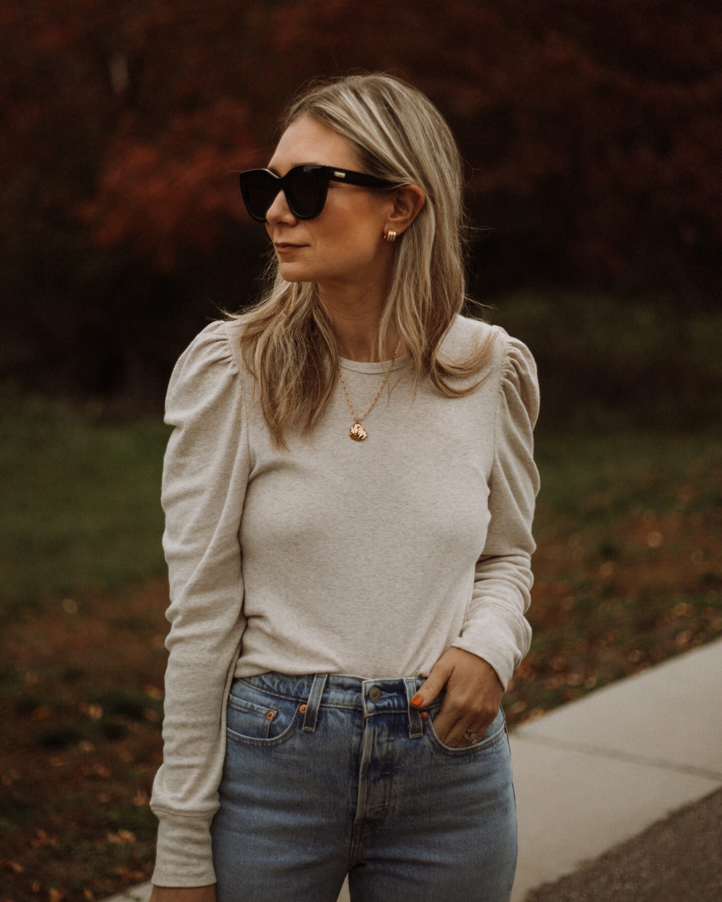 Karin Emily wear a puff sleeve top, light wash wedgie icon Levi jeans and le specs black air heart sunglasses