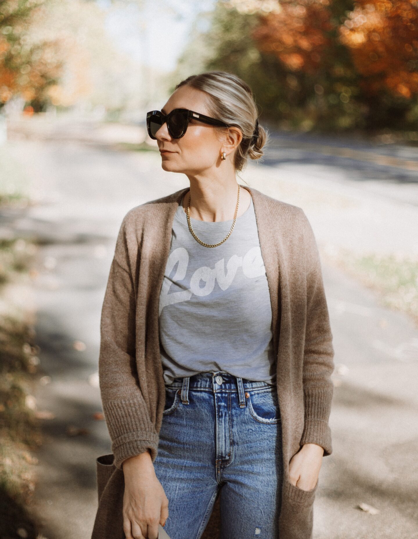 Karin Emily wears a graphic tee, cashmere cardigan, and distressed jeans