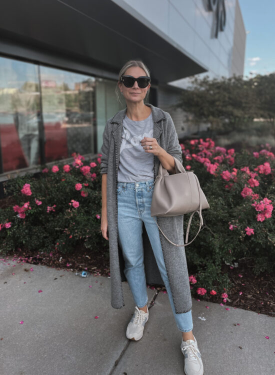 Karin Emily wears a fall maxi cardigan, graphic tee, light wash levi jeans and new balance sneakers