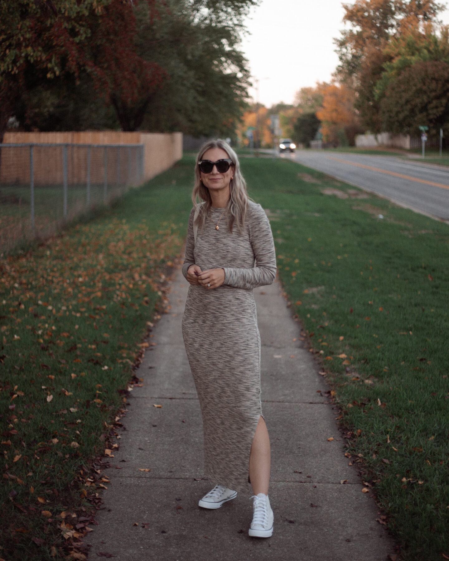 Karin Emily wears a long fall maxi dress with a pair of off white high top converse and oversized black le spec air heart sunglasses