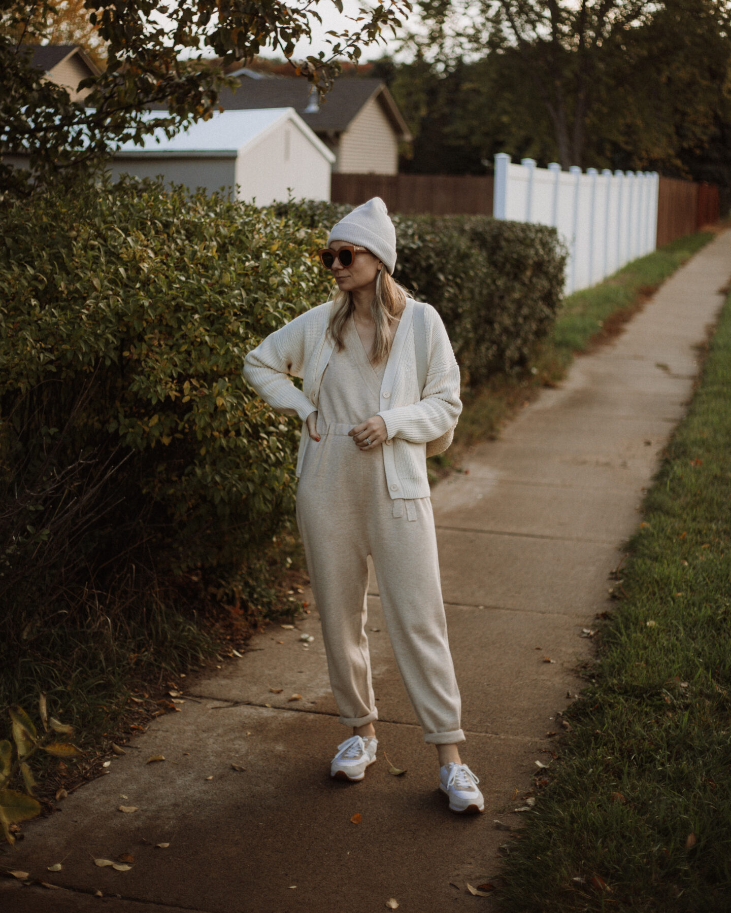 Karin Emily wears the Tradlands Shelter Cardigan, a J Crew Wool Jumpsuit and Sneakers and a Sherpa Backpack