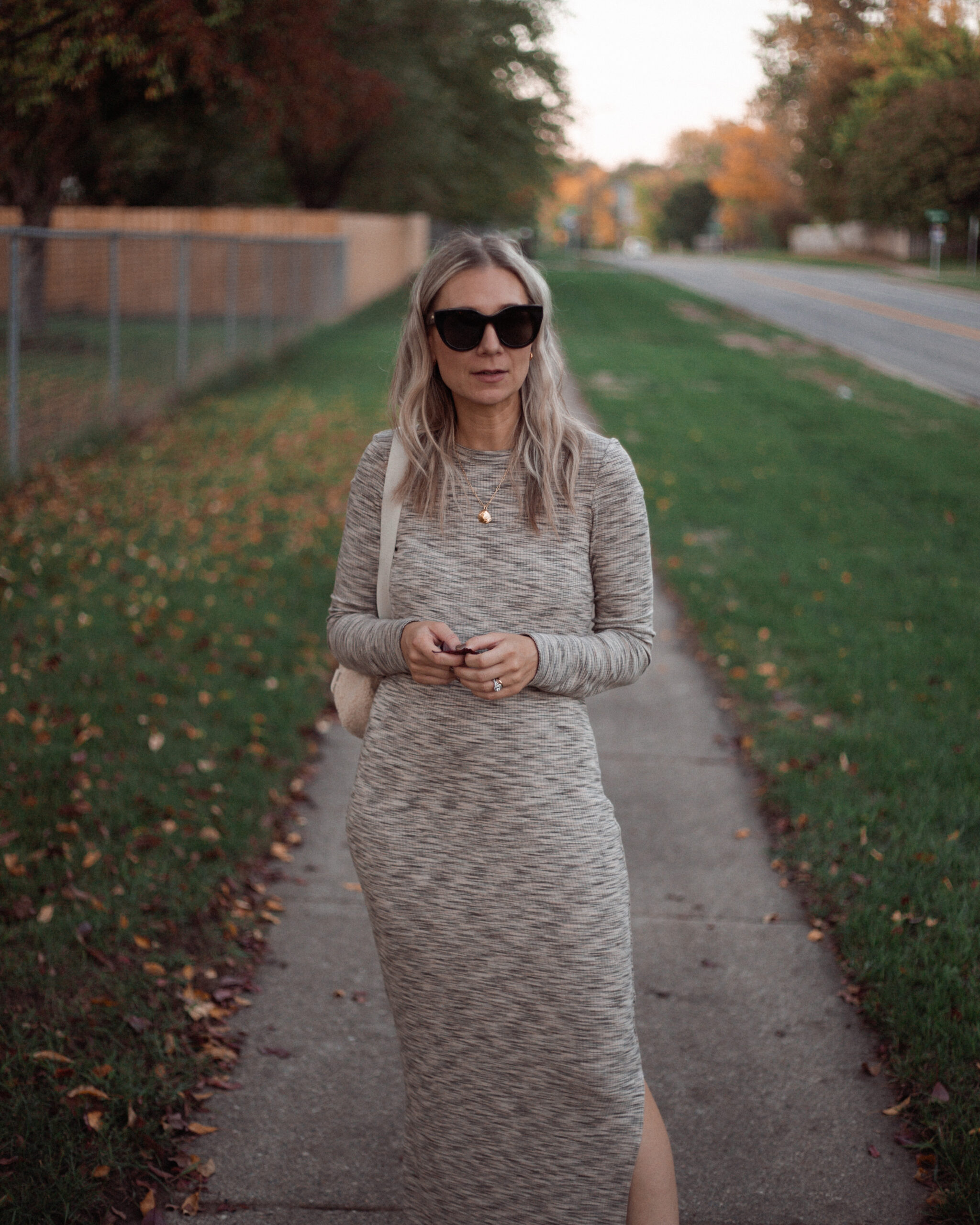 Karin Emily wears a long fall maxi dress with a pair of off white high top converse and oversized black le spec air heart sunglasses