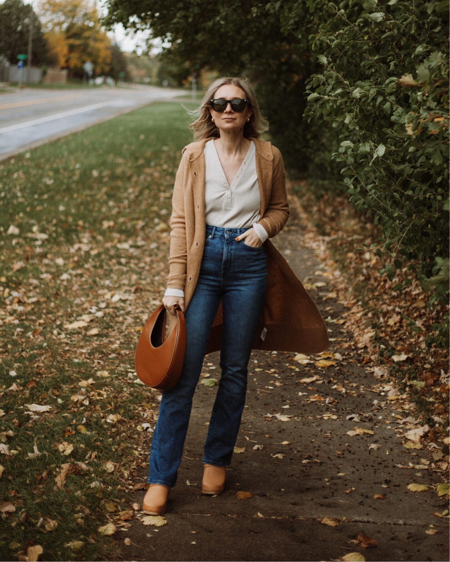 Karin Emily wears the cozy stretch duster from Everlane, a henley tee, and a staud moon bag