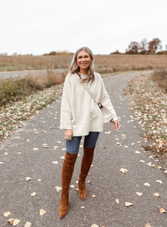 Karin Emily wears the Peaches sweater from Free People, dark wash skinny jeans, and brown over the knee boots
