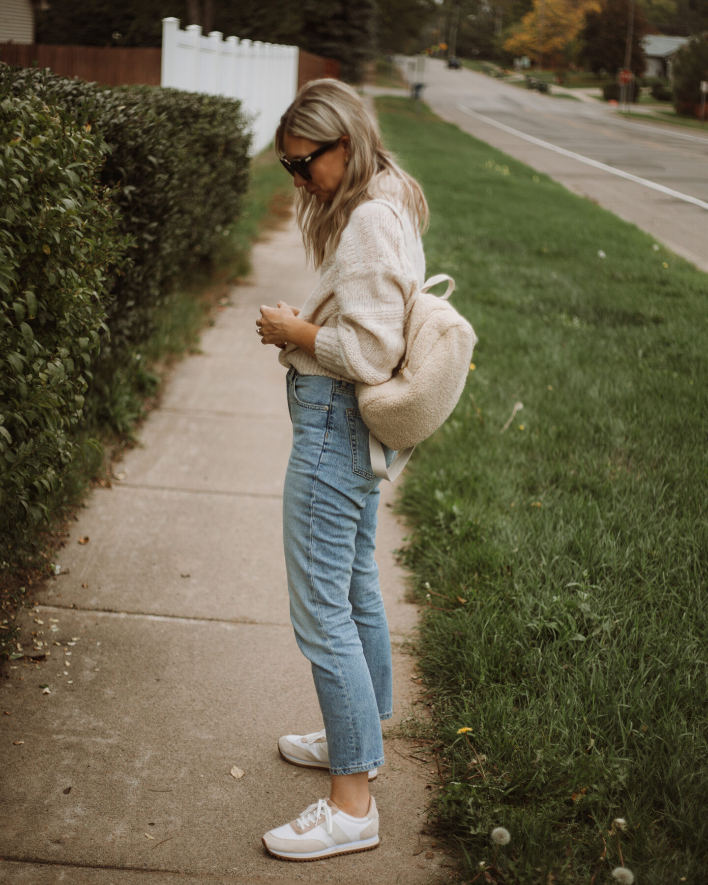 Karin Emily wears the Everlane puff sweater, light wash 90's cheeky jeans, and comfy sneakers