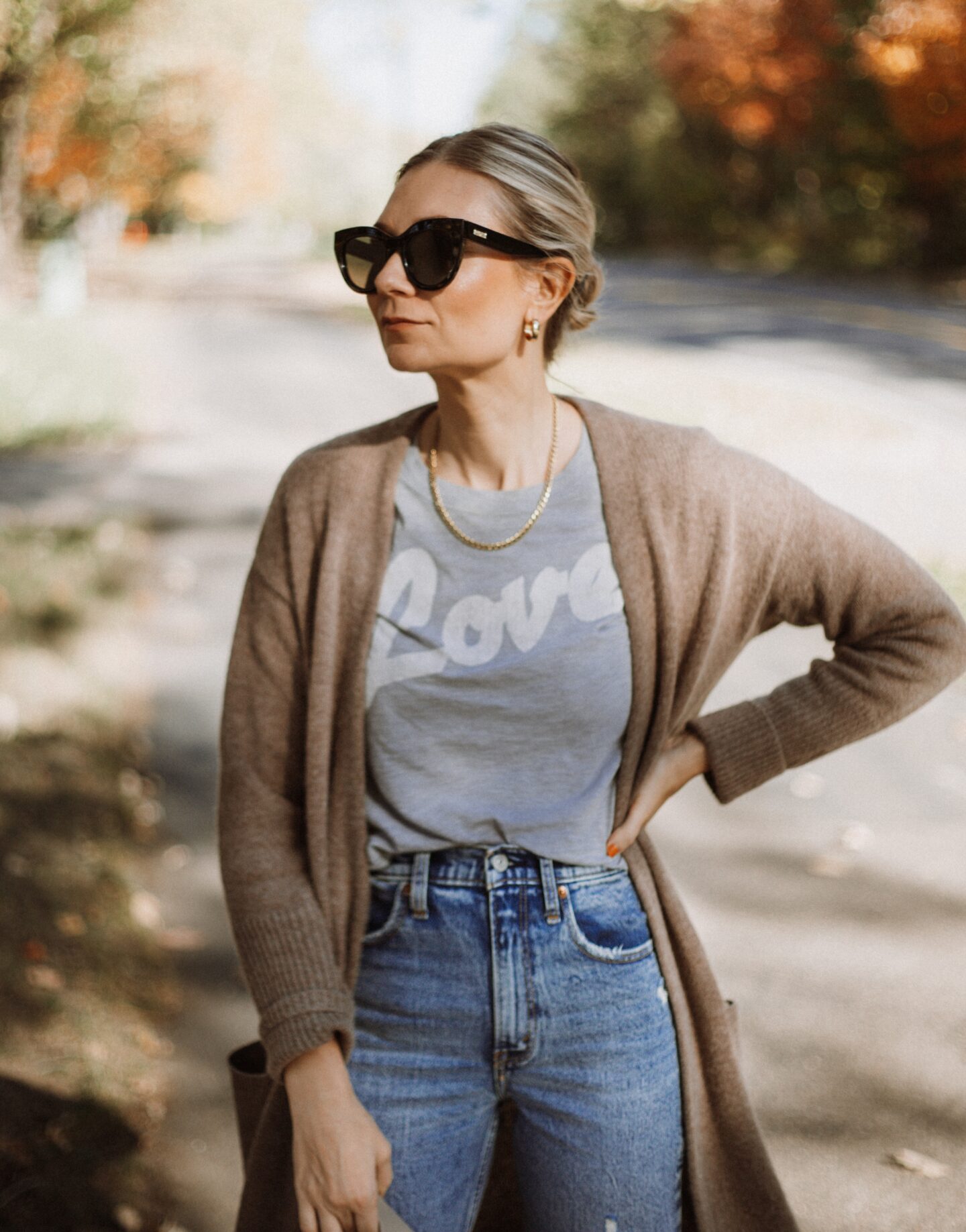 Karin Emily wears a graphic tee, cashmere cardigan, and distressed jeans