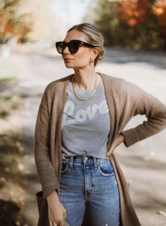 Karin Emily wears a graphic tee, cashmere cardigan, and distressed jeans