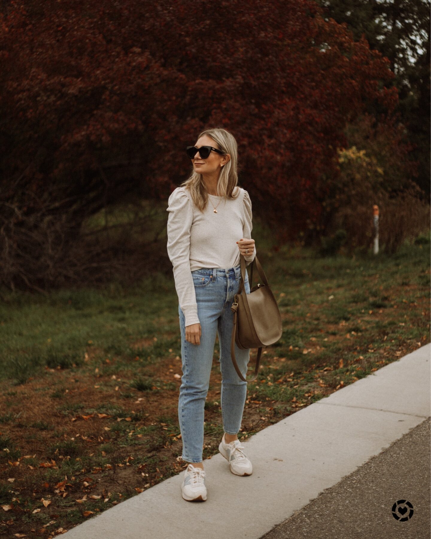 karin emily wears a puff sleeved top, light wash jeans, and new balance sneakers