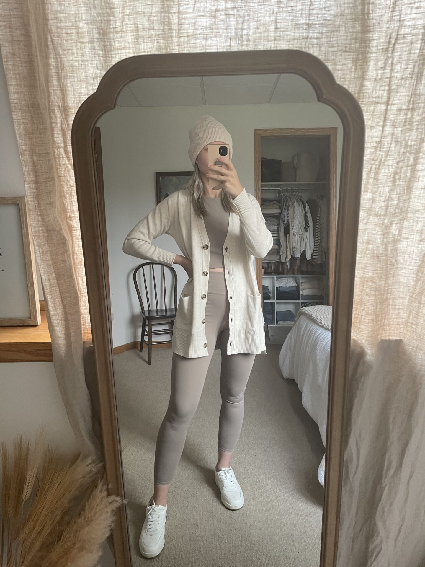 Karin Emily wears a madewell workout set, cream colored cardigan, and white leather sneakers