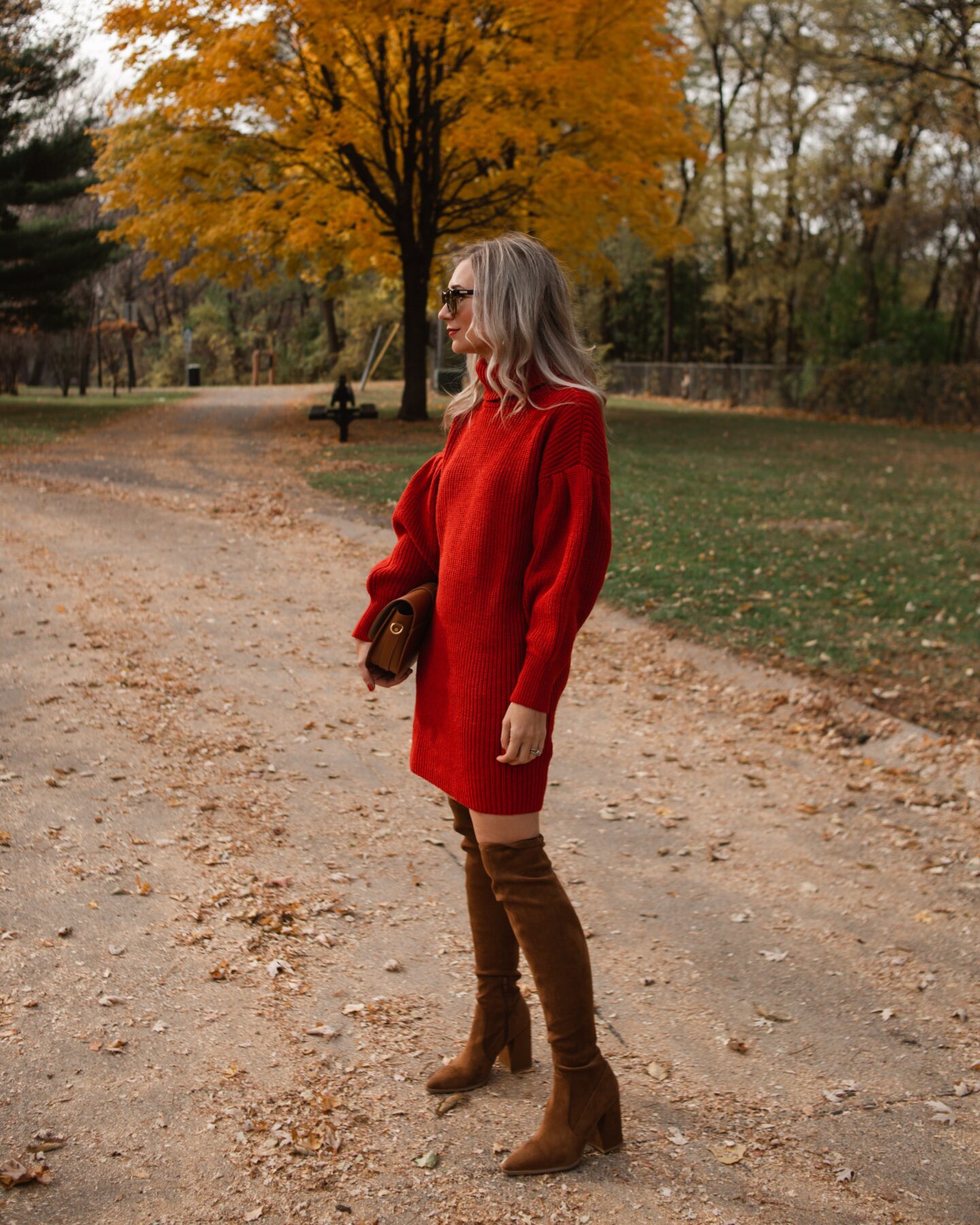 Karin Emily wears a red sweater dress from Free Assembly at Walmart and a pair of brown over the knee boots
