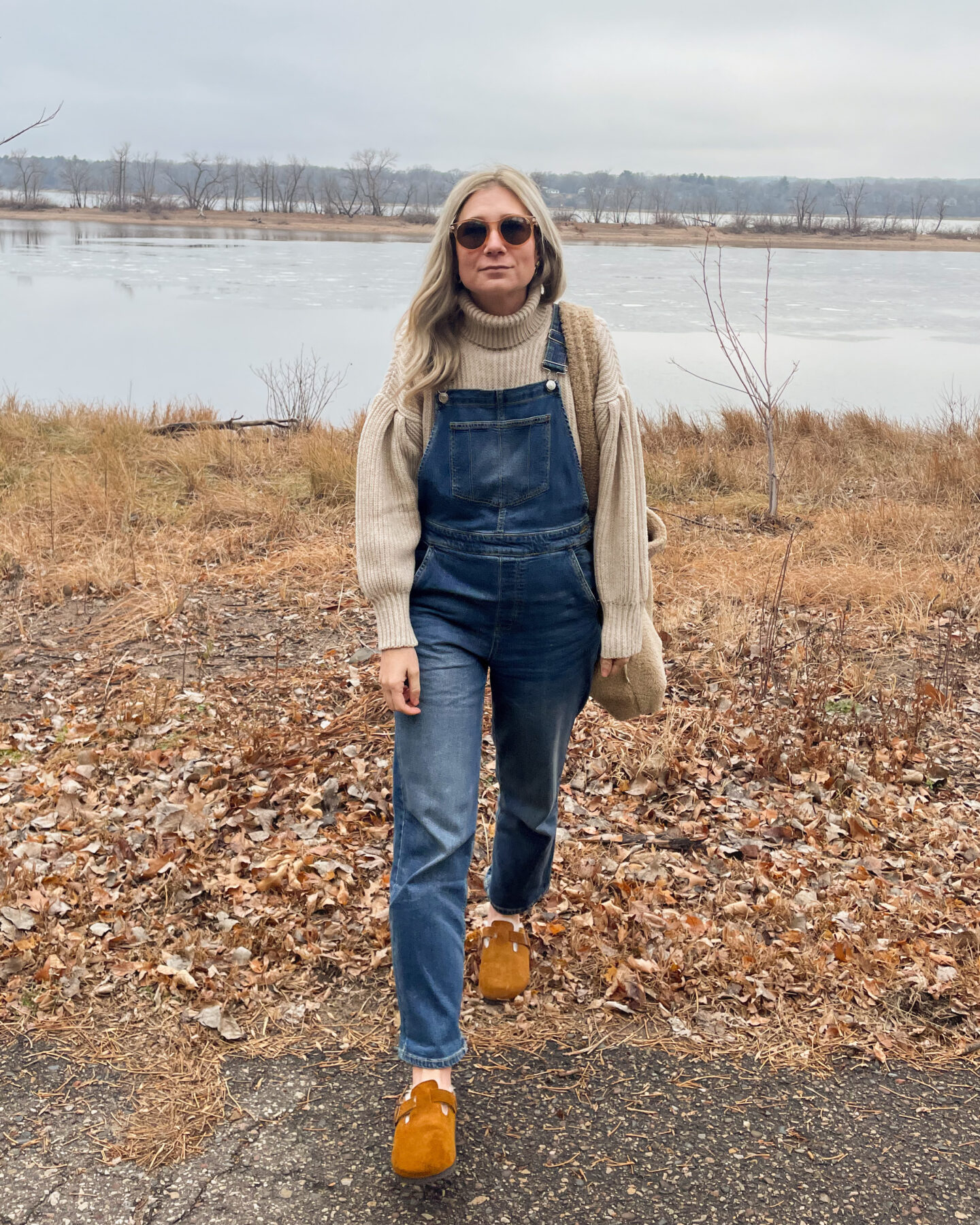 Karin Emily wears a statement sleeve turtleneck sweater and overalls from free assembly at walmart paired with birkenstock shearling clogs and a sherpa bag
