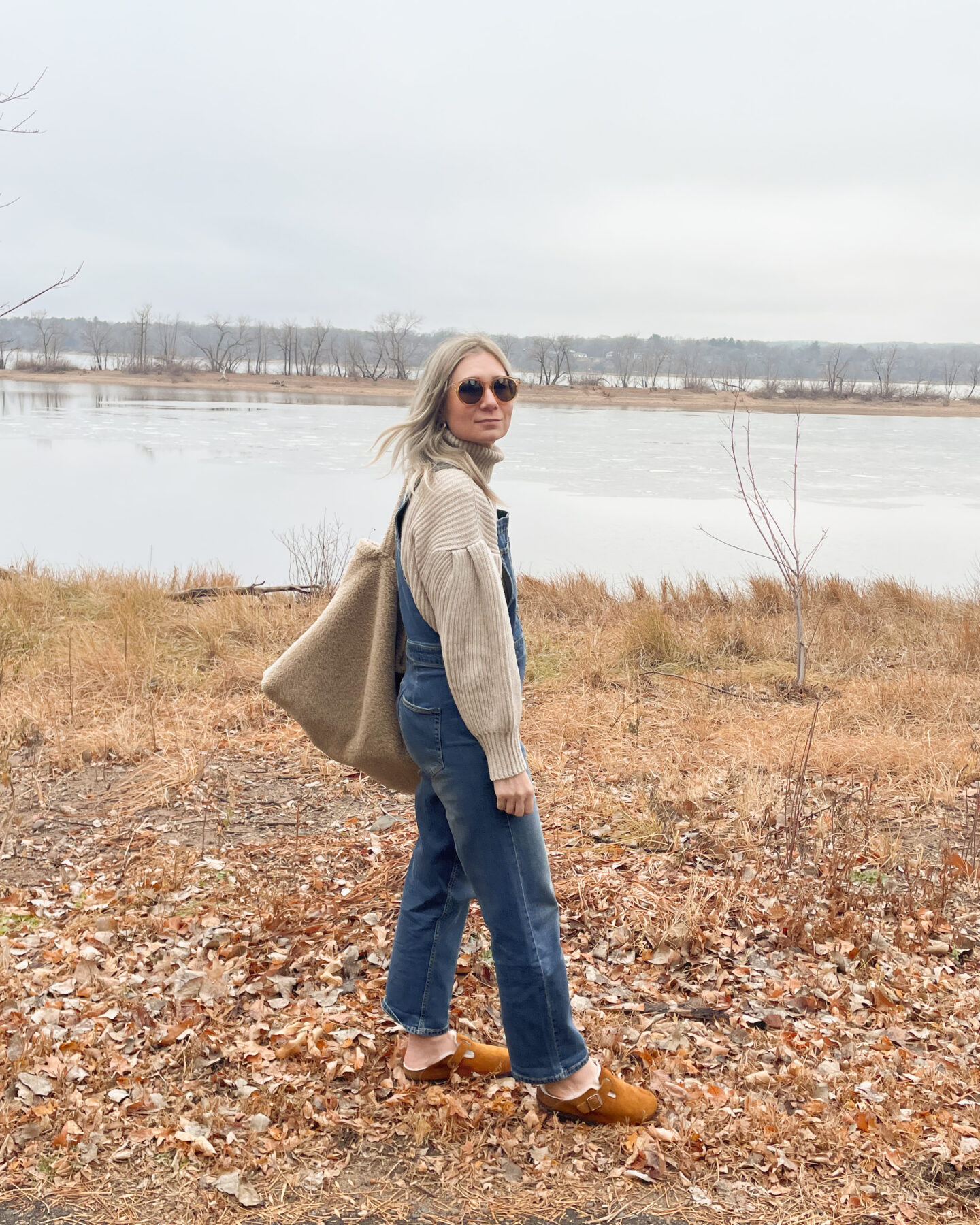 Karin Emily wears a statement sleeve turtleneck sweater and overalls from free assembly at walmart paired with birkenstock shearling clogs and a sherpa bag