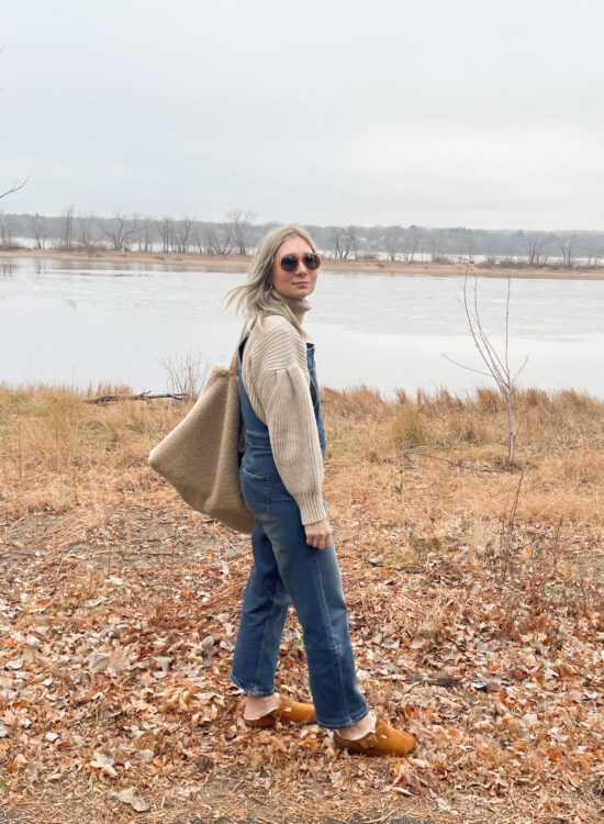 Karin Emily wears a statement sleeve turtleneck sweater and overalls from free assembly at walmart paired with birkenstock shearling clogs and a sherpa bag