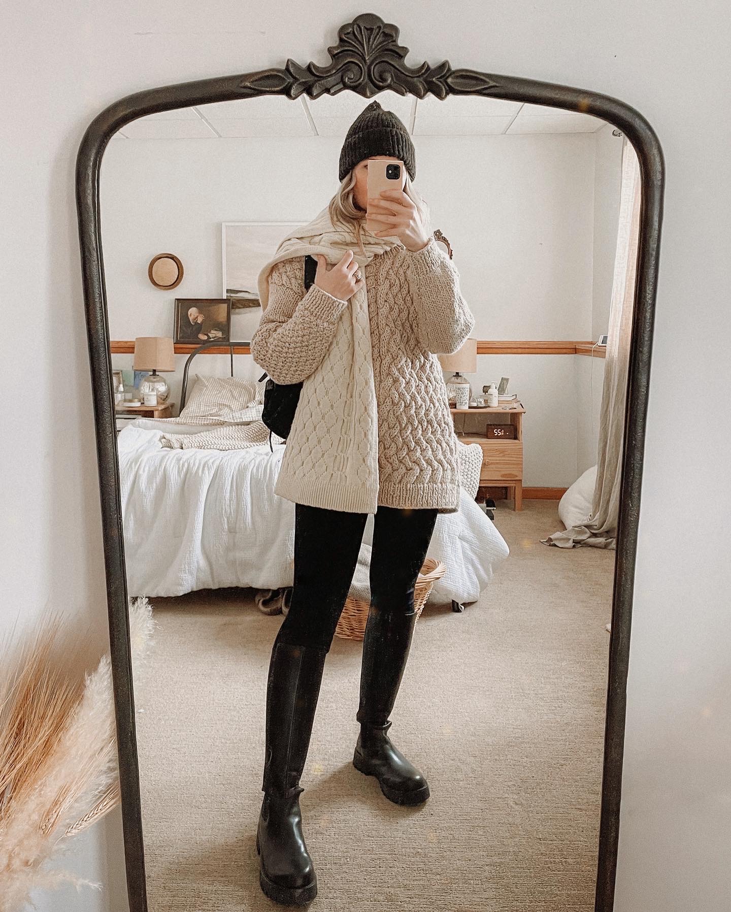 Karin Emily wears a handmade alpaca sweater, black leggings, and black knee high lug boots