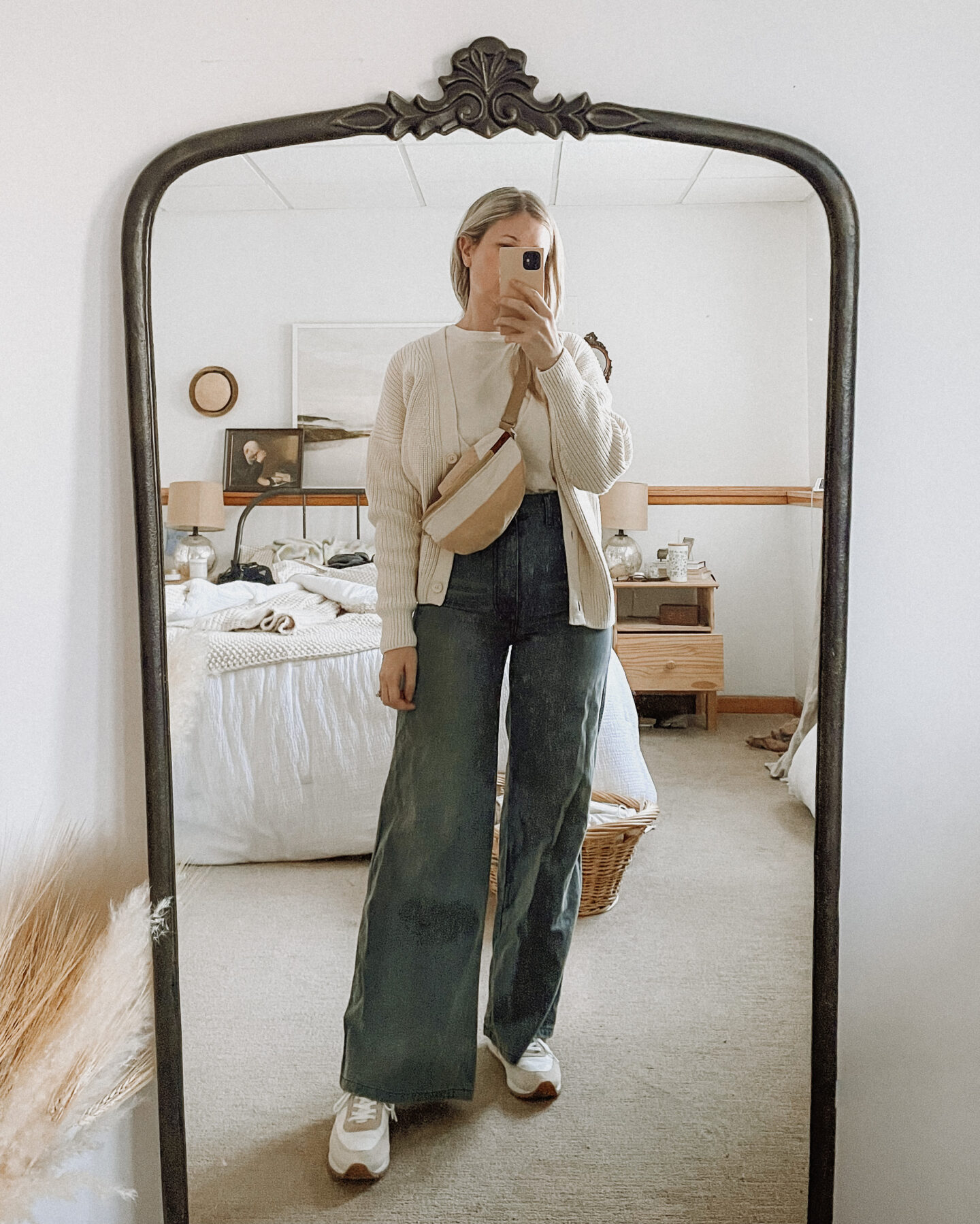 Karin Emily wears a tradlands shelter cardigan, doen wide leg jeans, j. crew sneakers, and a quilted fanny pack