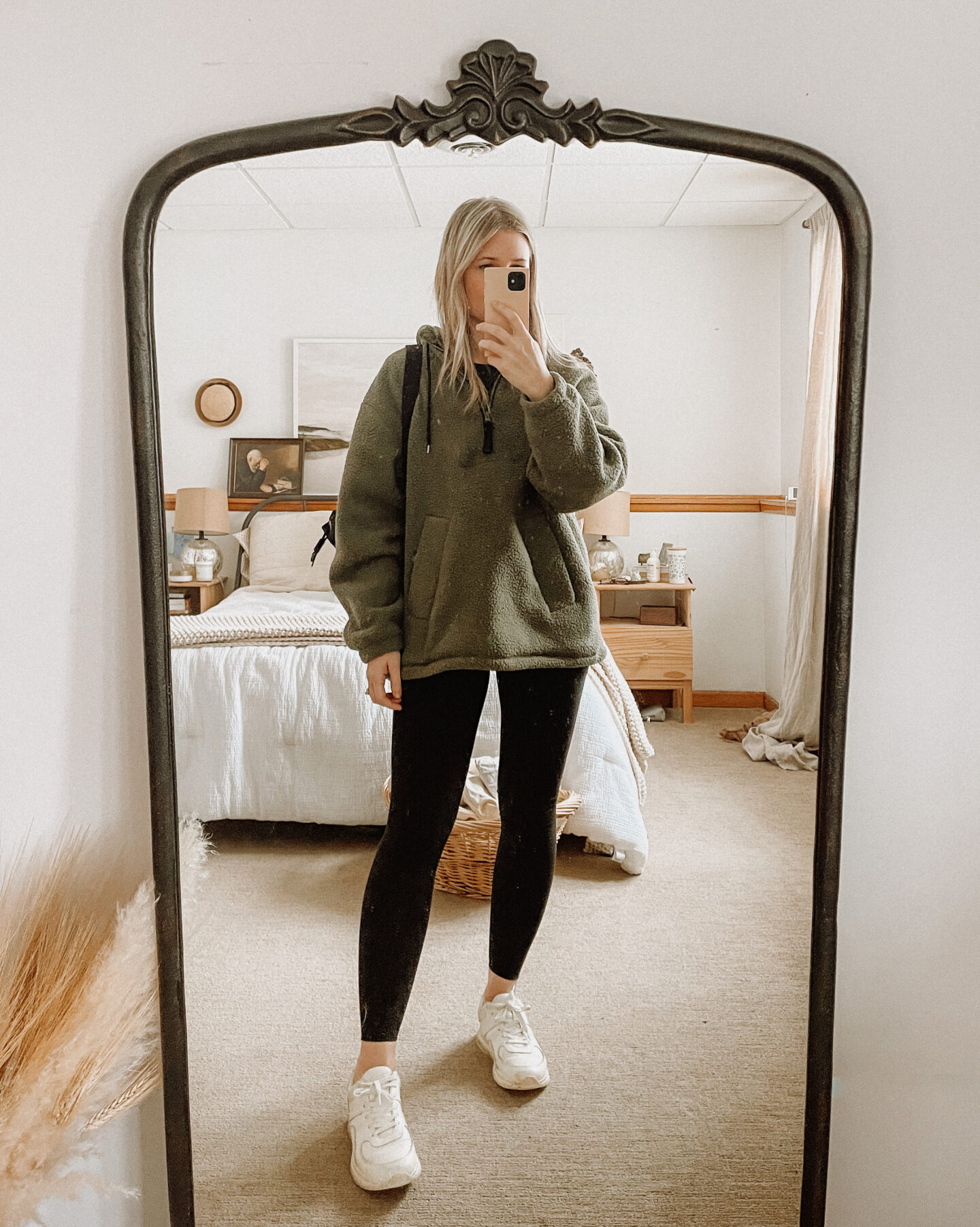 Karin Emily wears a green fleece tunic pullover over Everlane's new leggings, and Everlane tread sneakers