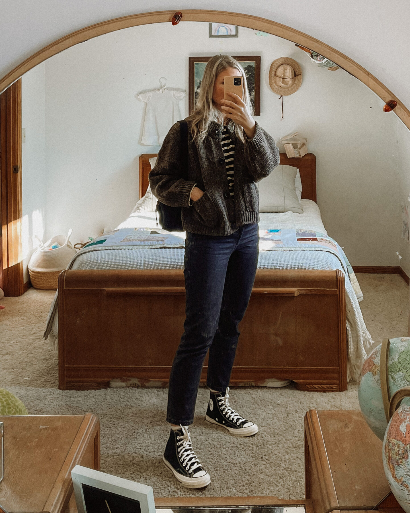 Karin Emily wears a Babaa cardigan no. 23, an everlane breton stripe long sleeve tee, black wash everlane 90's cheeky jeans, and a pair of black converse high top sneakers
