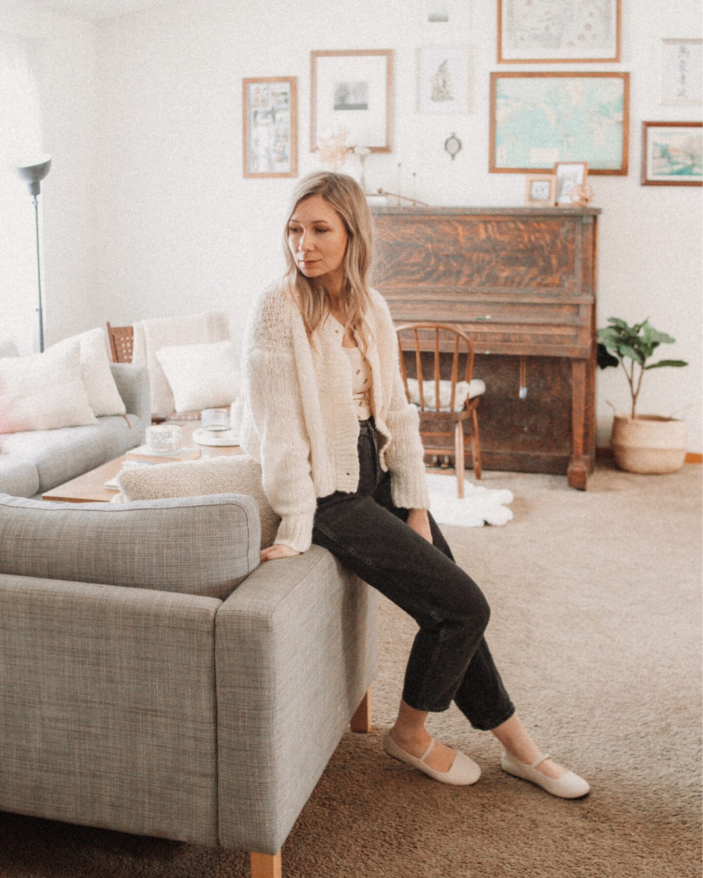 Karin Emily wears a chunky cardigan from Everlane, an arq tank top, black balloon jeans from J. Crew, and cream Mary Jane Flats