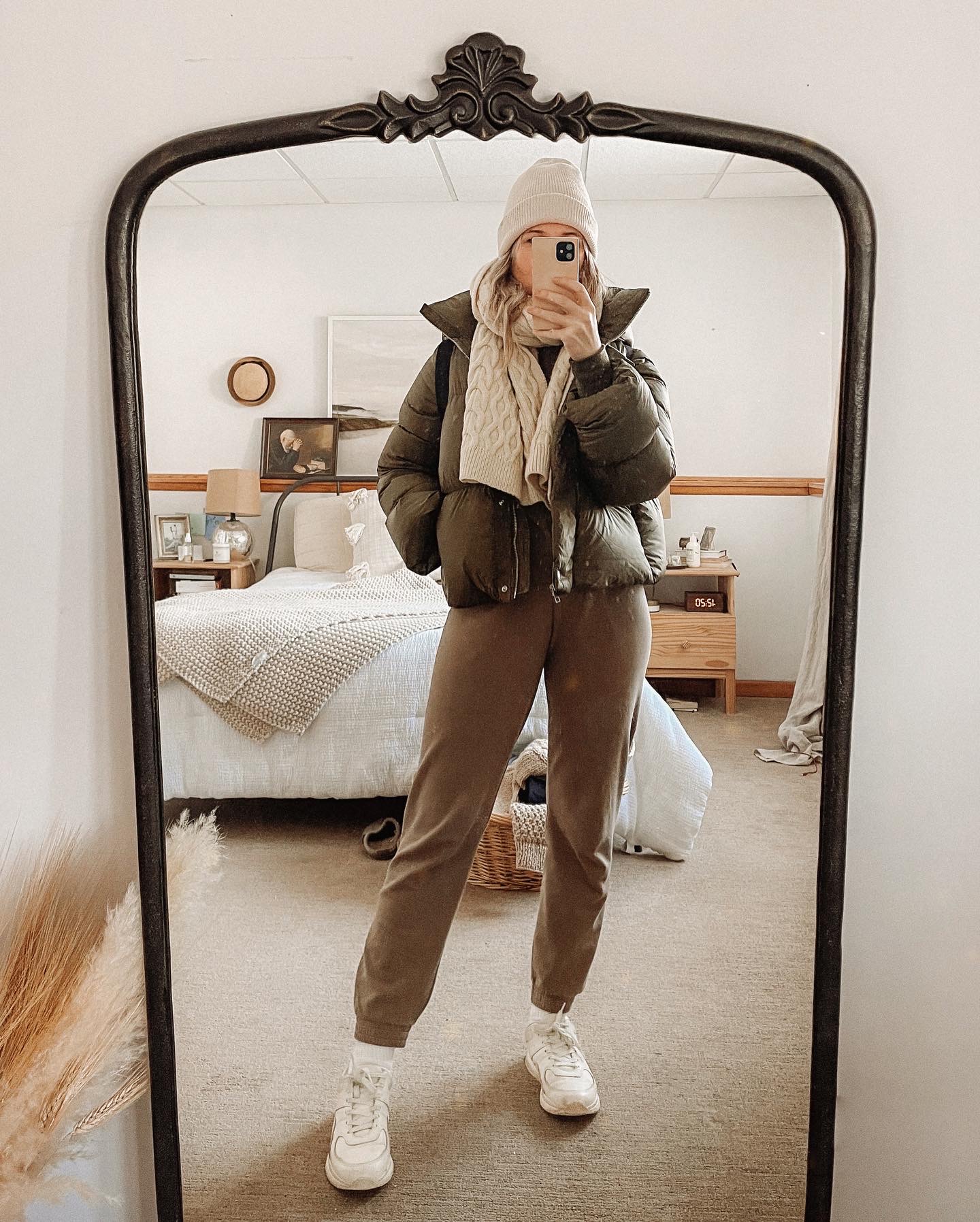 Karin Emily wears an olive green puffer coat and matching olive green jogger set