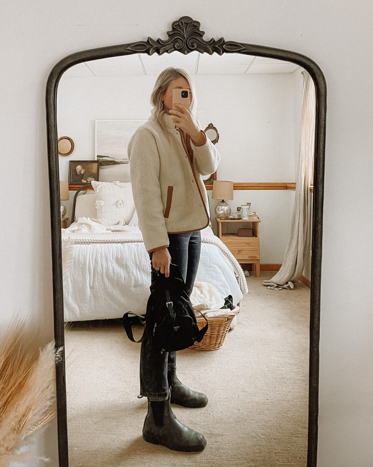 Karin Emily wears a fleece jacket, black everlane 90s jeans, blundstone boots, and a prada backpack