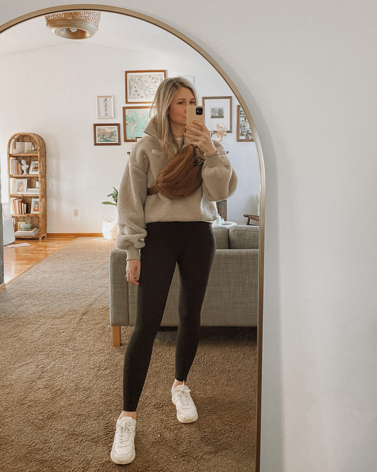 Karin Emily wears a cropped fleece jacket from the North Face, Everlane black leggings, and cream tread sneakers from Everlane