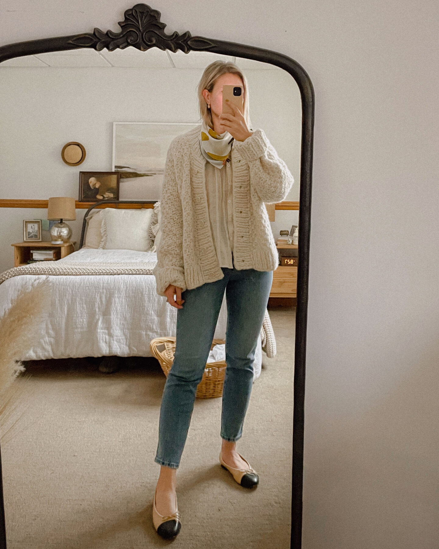 Karin Emily wears a cozy cardigan and silk scarf over a lightweight blouse, madewell perfect vintage jeans, and two tone cap toe flats