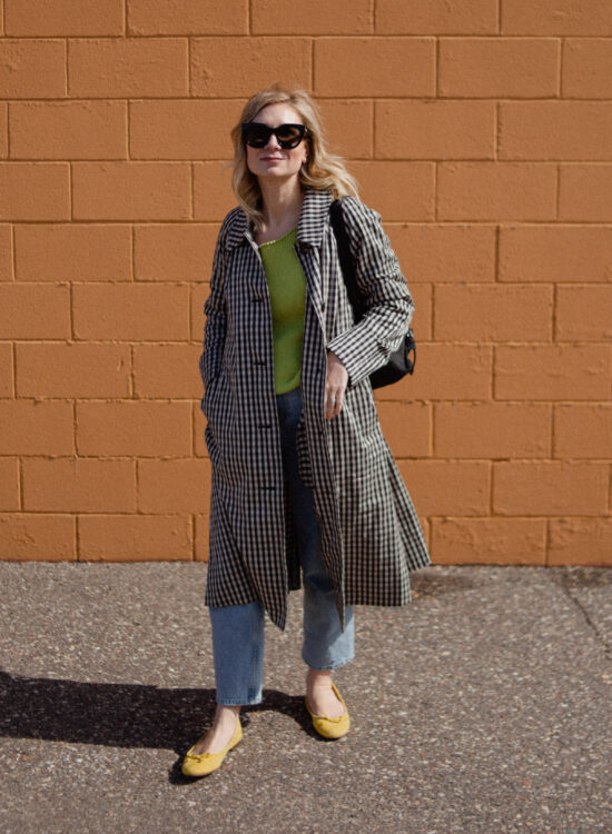 Karin Emily wears a gingham trench coat and light wash way high jeans from the Everlane March Edit