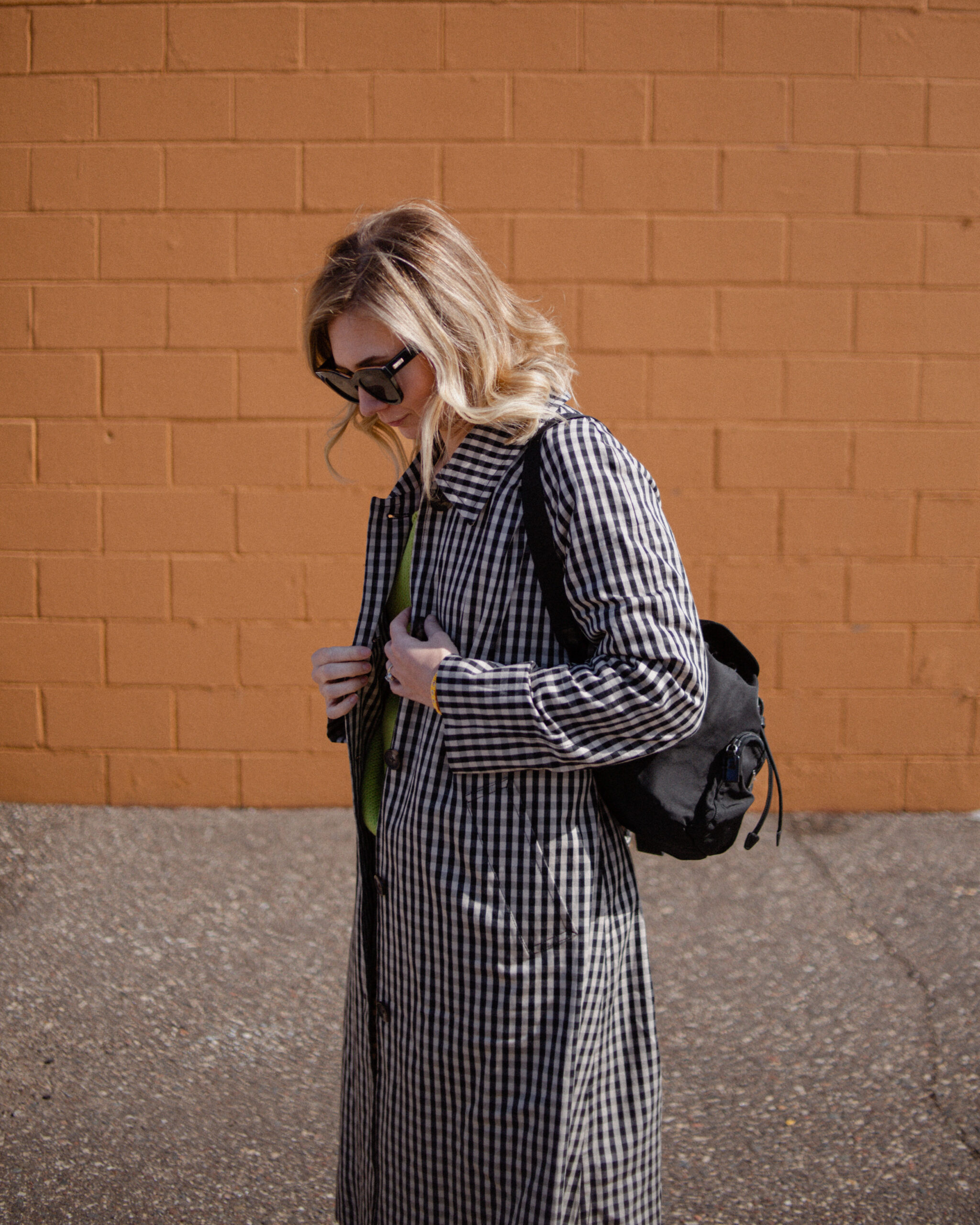 Karin Emily wears a gingham trench coat and light wash way high jeans from the Everlane March Edit